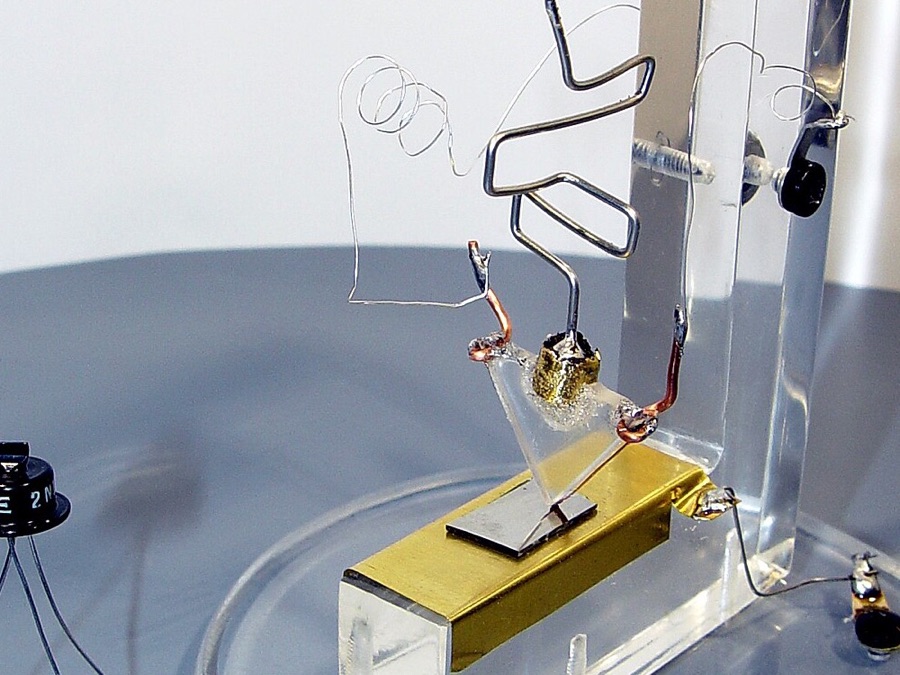 Réplica do primeiro transistor da Bell Labs ao lado de um transistor comercial